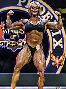 Aleesha Young doing a front double biceps pose at the 2017 Rising Phoenix World Championships.